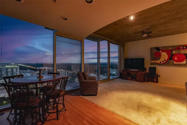 a dining room with furniture and a floor to ceiling window