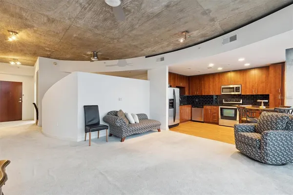 a living room with furniture and kitchen view