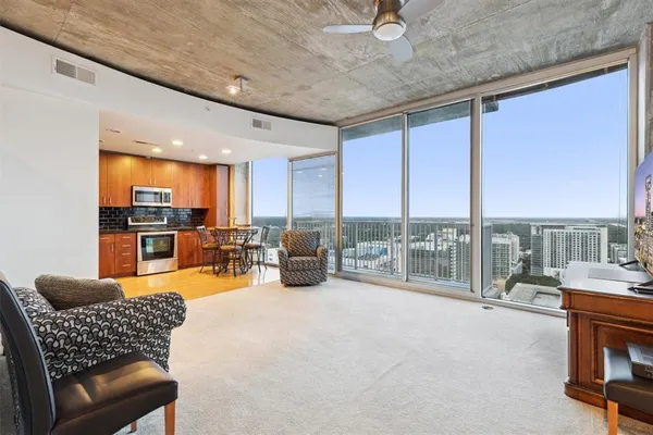 a living room with furniture floor to ceiling window and table