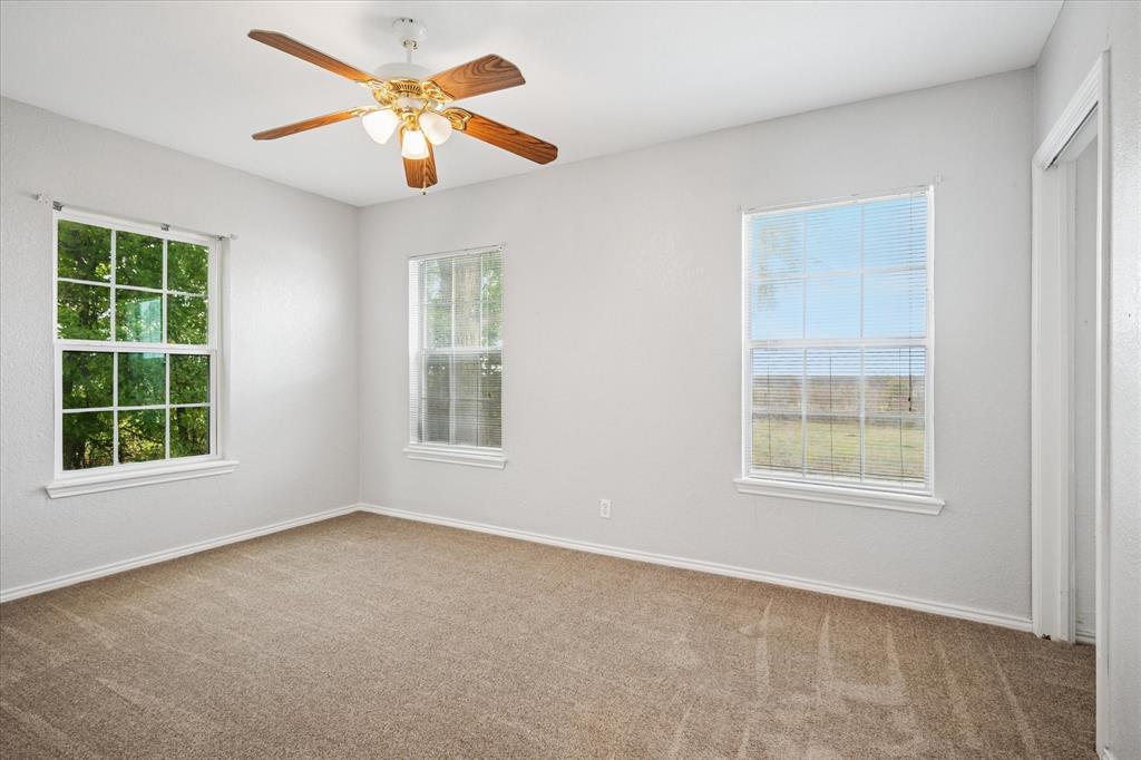 9828 County Road Alvarado, TX 76009 - Photo 12 of 20 an empty room with a window and a fan