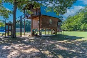 a view of a house with backyard and a tree