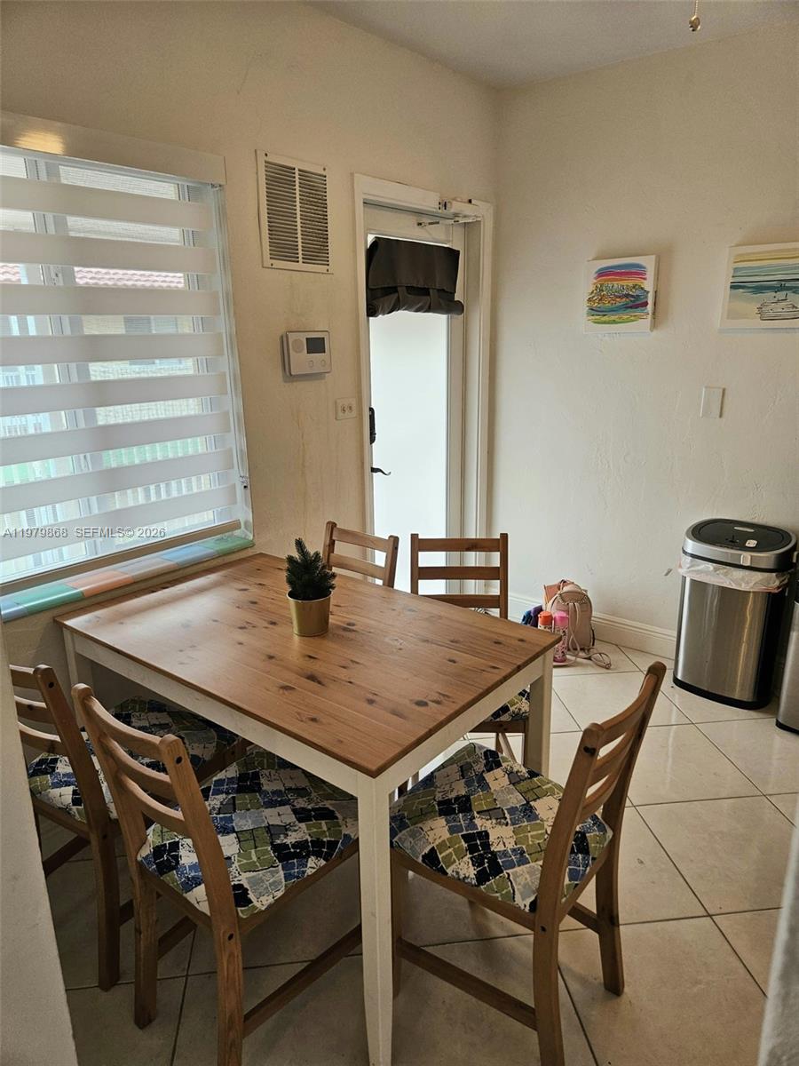 7400 Harding Avenue, Unit 22 Miami Beach, FL 33141 - Photo 16 of 26 a table with chairs and a stove top oven