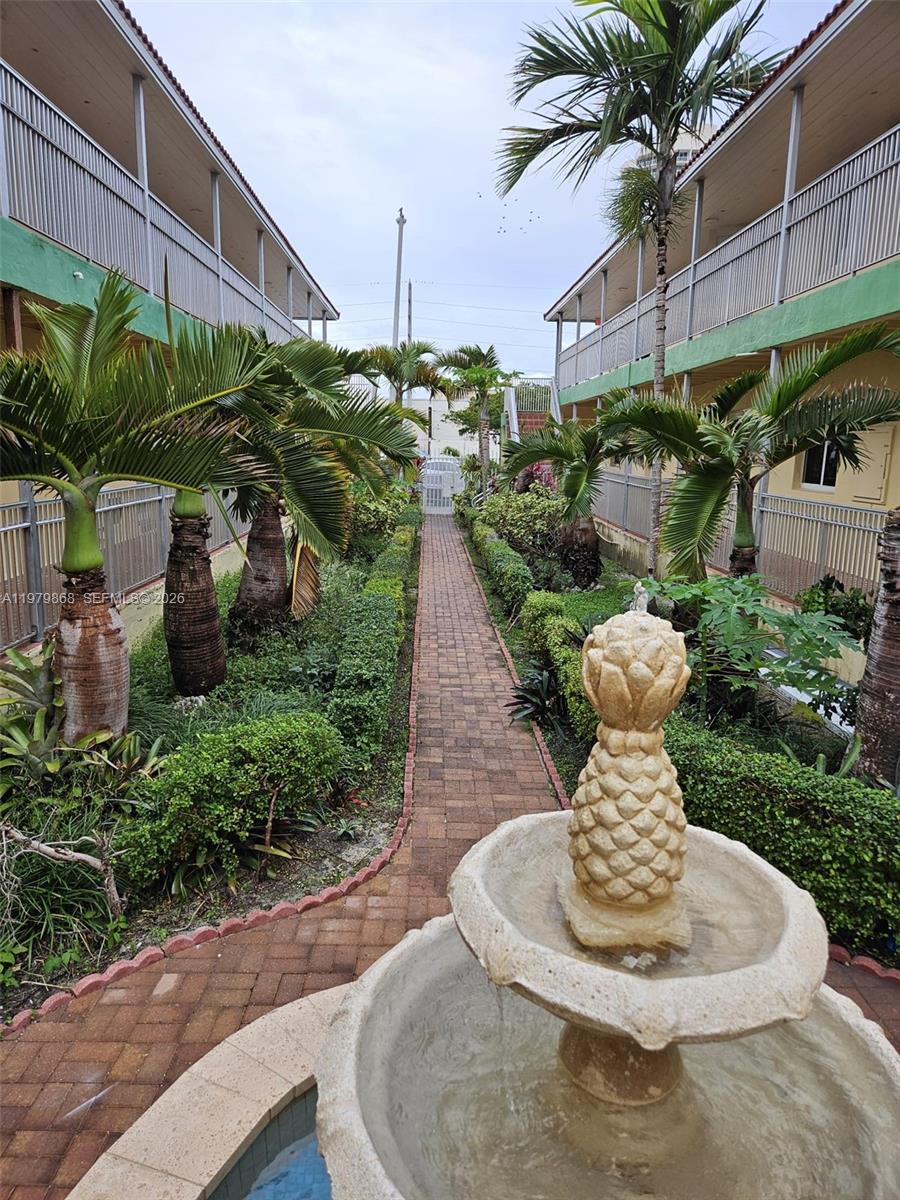 7400 Harding Avenue, Unit 22 Miami Beach, FL 33141 - Photo 25 of 26 a vase of flowers sitting on a table in front of a building