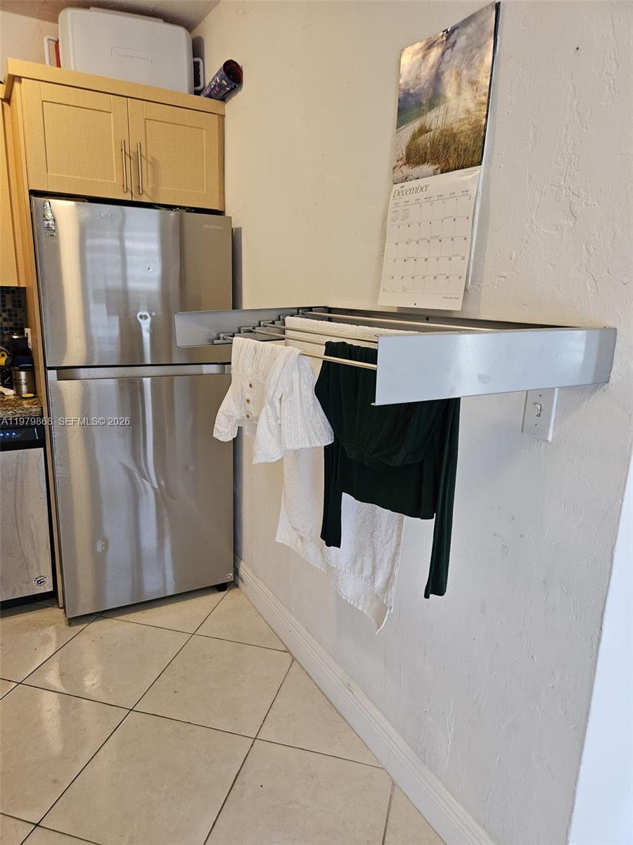 7400 Harding Avenue, Unit 22 Miami Beach, FL 33141 - Photo 4 of 26 a kitchen with a refrigerator and a wall