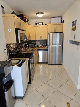 a kitchen with stainless steel appliances granite countertop a stove a refrigerator and a microwave