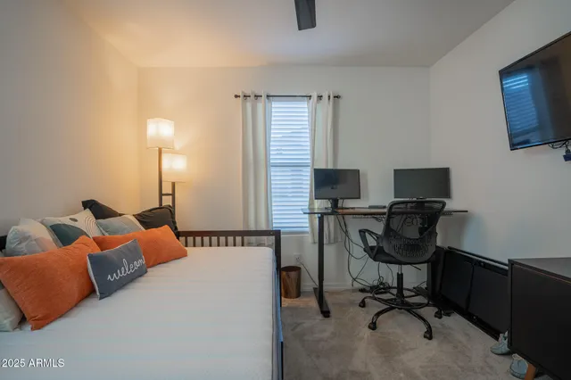 a view of a workspace with furniture and a window