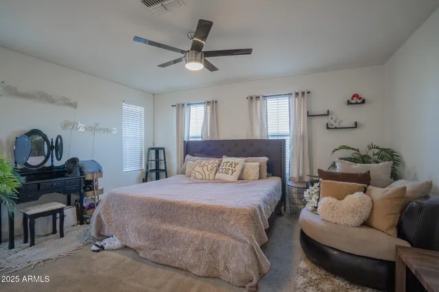 a bedroom with a bed a couch and a potted plant