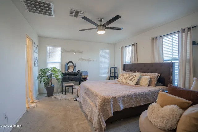 a bedroom with a bed furniture and a ceiling fan