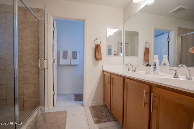 a bathroom with a double vanity sink a mirror and shower