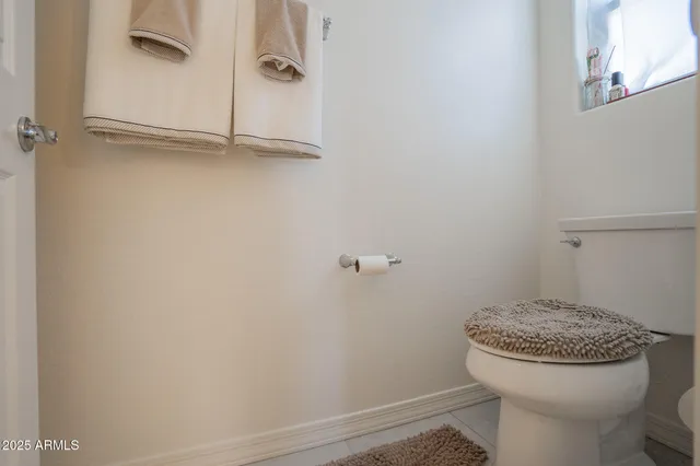 a bathroom with a granite countertop toilet and a sink
