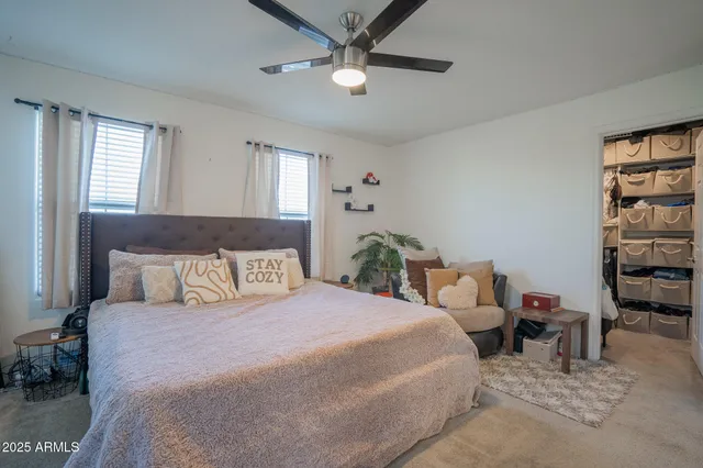 a bedroom with a bed a dresser and a chandelier