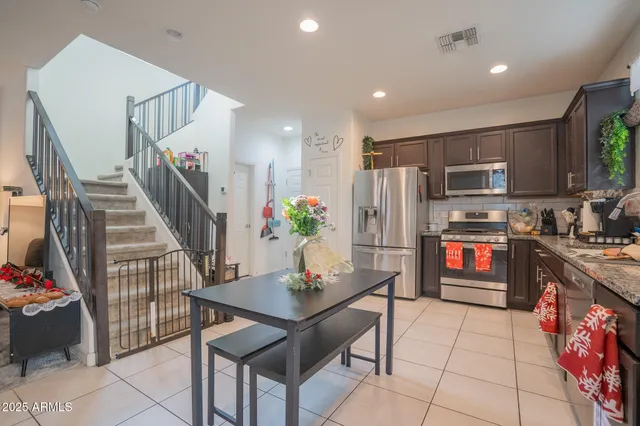 a kitchen with stainless steel appliances granite countertop a refrigerator and a stove top oven