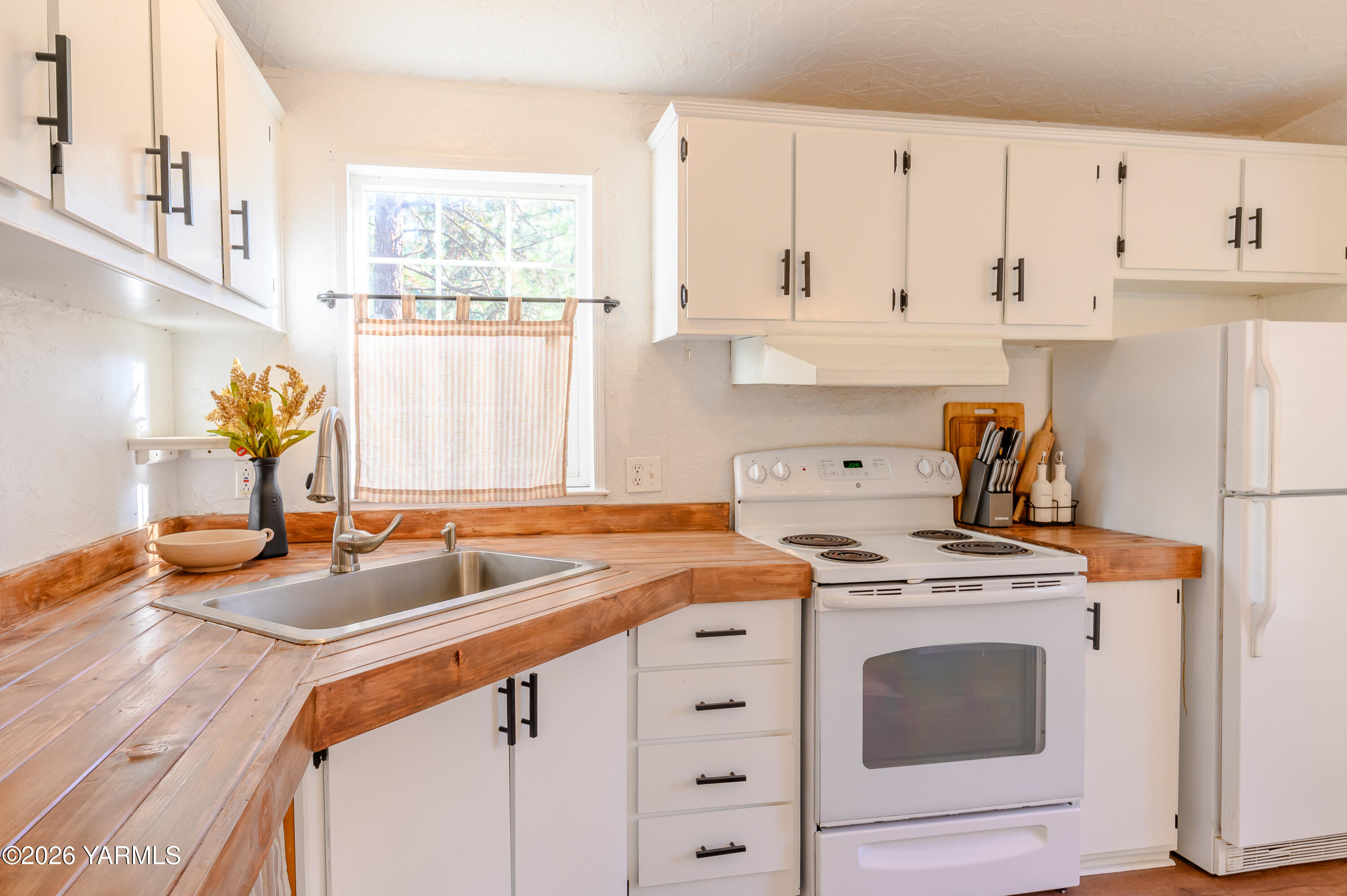 6371 Fork Road North Yakima, WA 98903 - Photo 4 of 19 a kitchen with stainless steel appliances granite countertop a sink stove and white cabinets with wooden floor