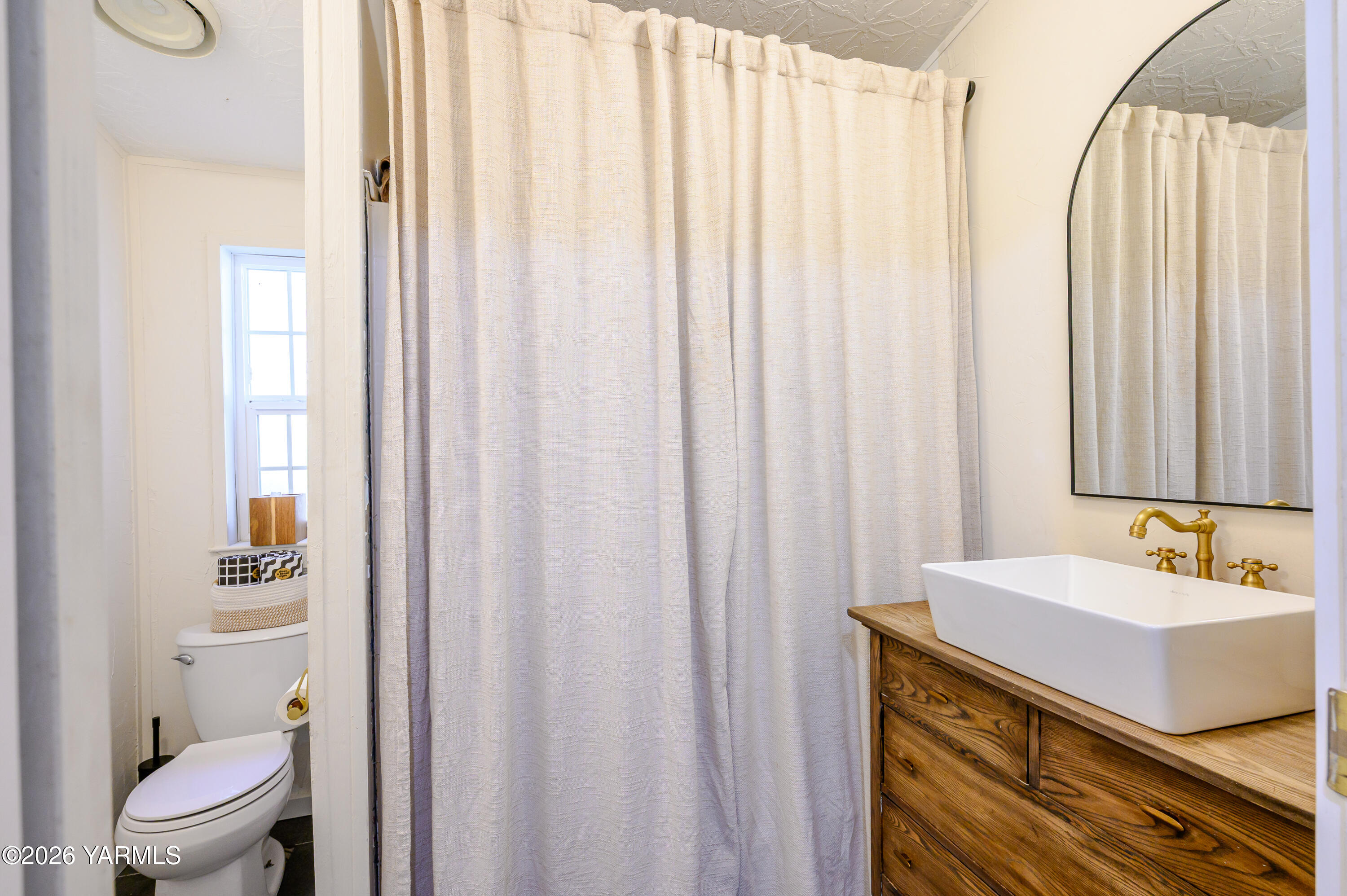 6371 Fork Road North Yakima, WA 98903 - Photo 10 of 19 a bathroom with a sink a toilet and shower curtain