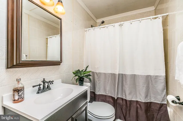 a bathroom with a sink a toilet a mirror and shower curtain