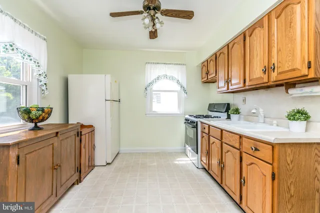 a kitchen with stainless steel appliances granite countertop a sink a stove cabinets and a window
