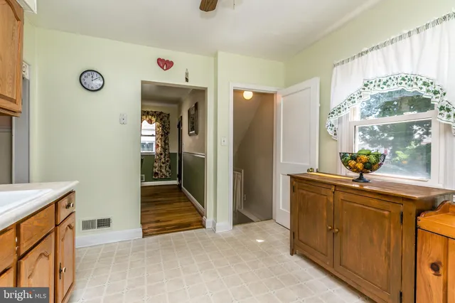 a view of hallway with window and wooden floor