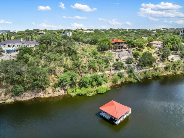 an aerial view of residential houses with outdoor space and lake view