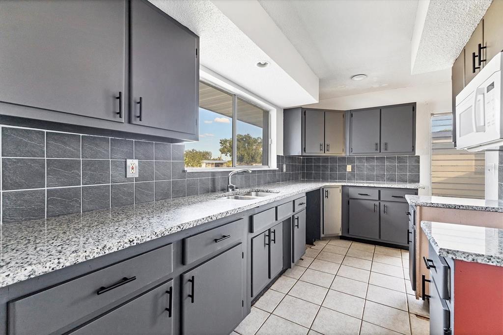 2529 Ednor Street Port Charlotte, FL 33952 - Photo 13 of 23 a kitchen with a sink window and cabinets