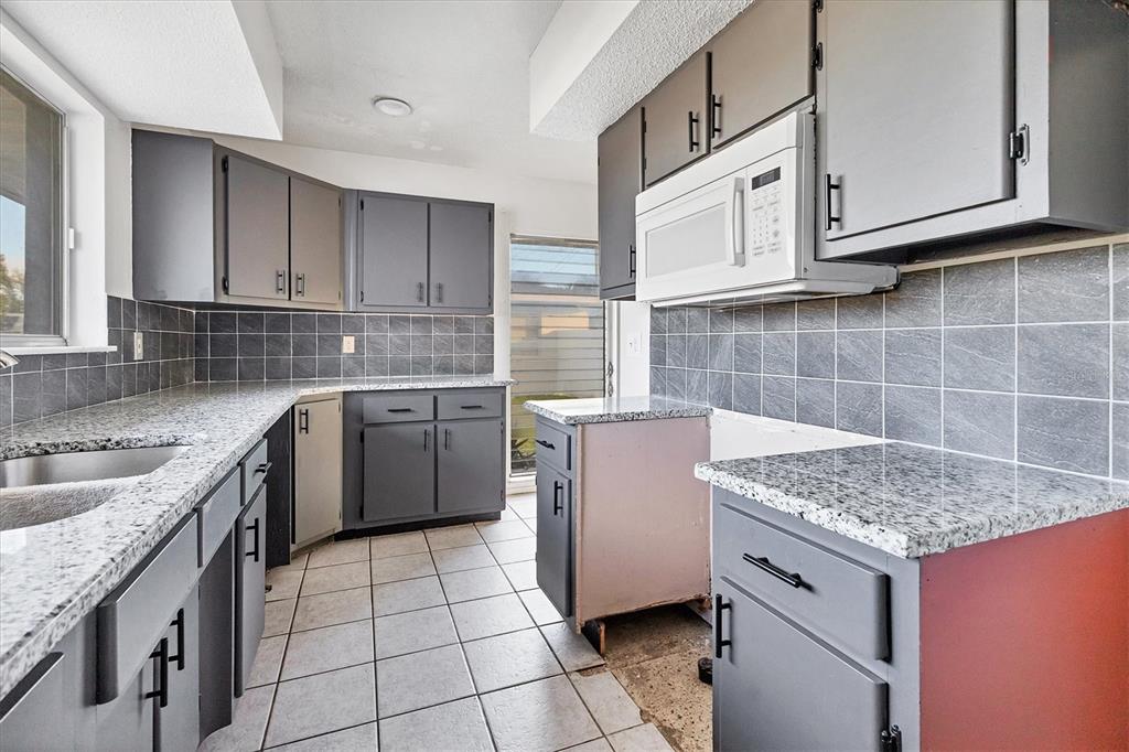 2529 Ednor Street Port Charlotte, FL 33952 - Photo 14 of 23 a kitchen with stainless steel appliances granite countertop a sink stove and cabinets