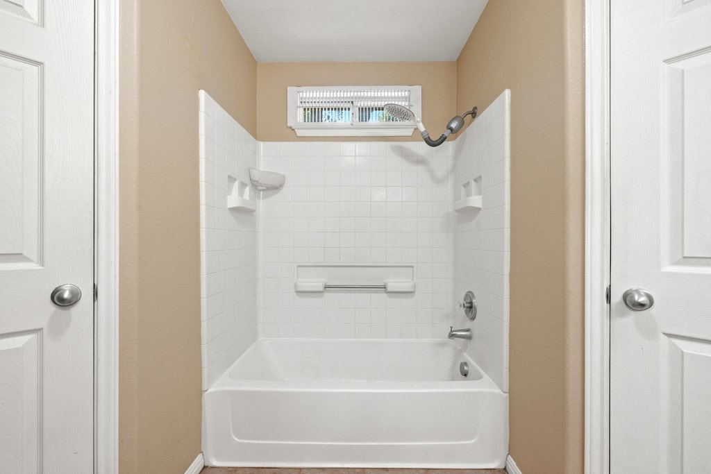 5208 Sioux Lane Austin, TX 78734 - Photo 24 of 35 A well-maintained bathroom featuring a classic tub and shower combination with clean tile surround.