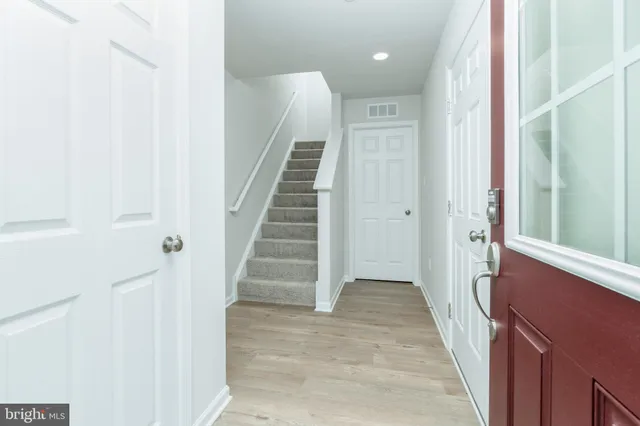 a view of a hallway with wooden floor and entryway