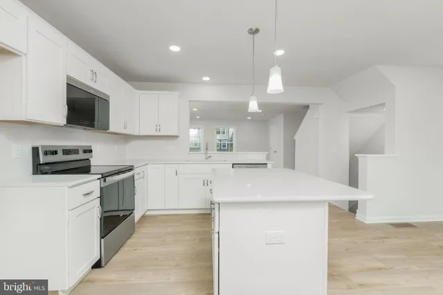 a kitchen with kitchen island a sink stainless steel appliances and cabinets
