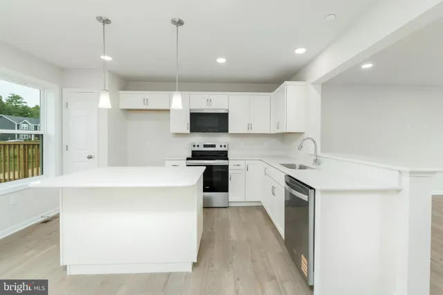 a kitchen with a sink a counter top space stainless steel appliances and a window