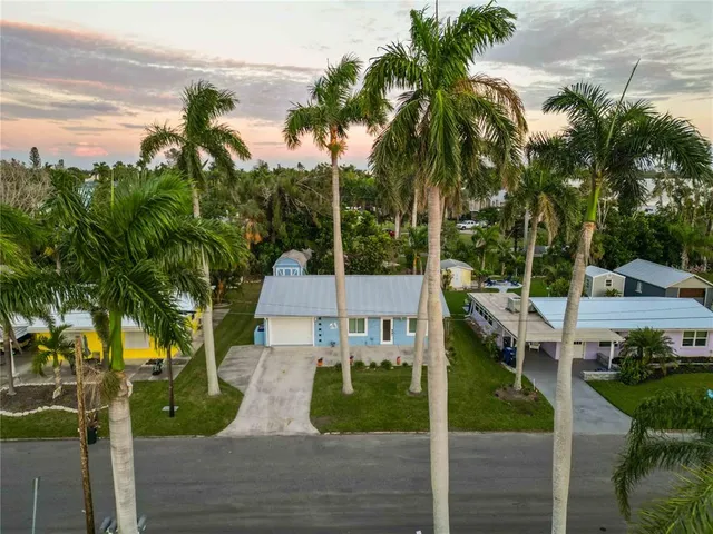 a front view of a house with a yard and potted plants