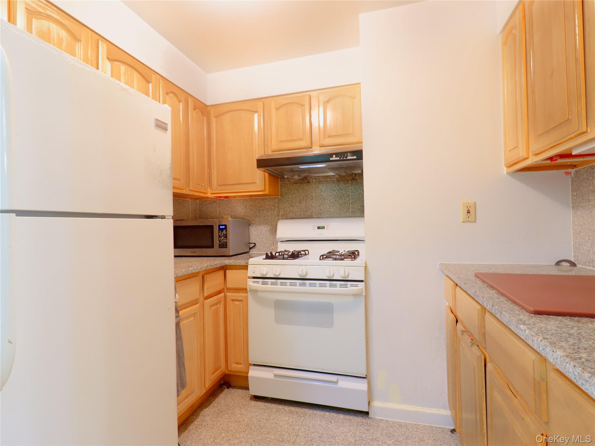 137-08 31st Road, Unit 5E Queens, NY 11354 - Photo 13 of 14 a kitchen with a stove a sink and a refrigerator