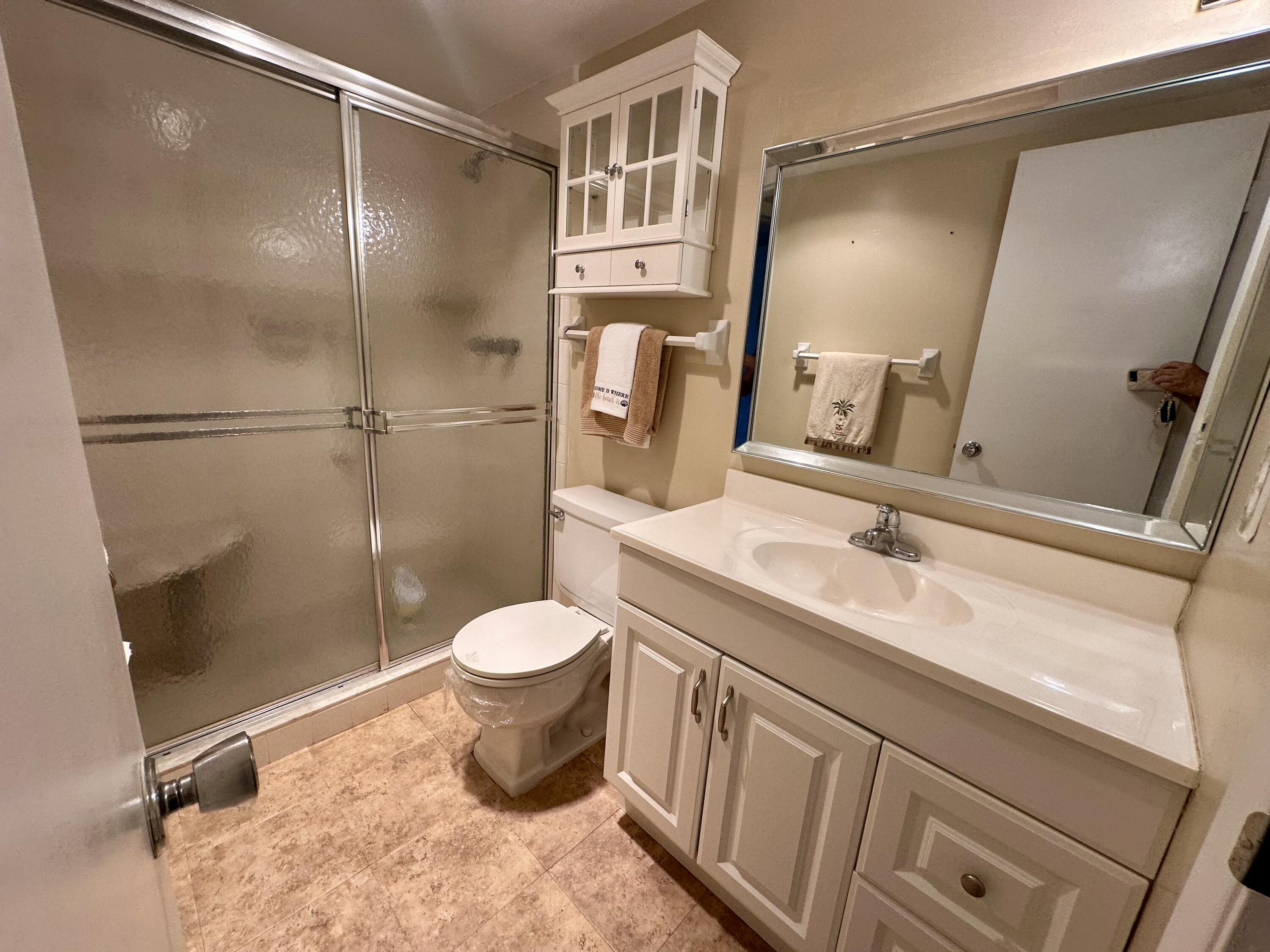 3 Garden Street, Unit 105K Tequesta, FL 33469 - Photo 11 of 41 a bathroom with a granite countertop sink toilet and shower