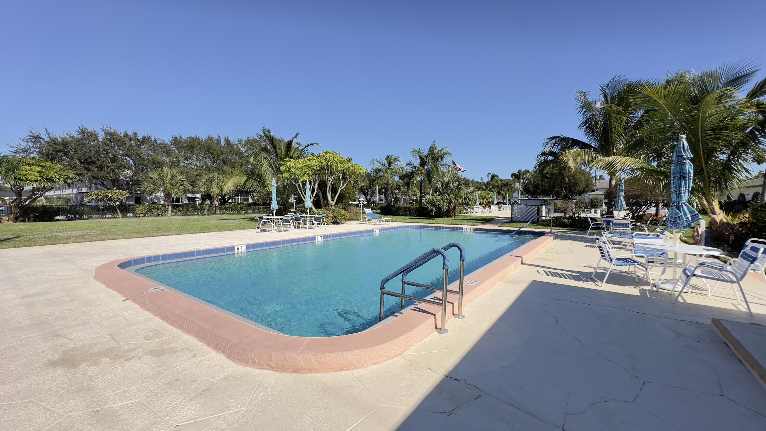 3 Garden Street, Unit 105K Tequesta, FL 33469 - Photo 20 of 41 a view of a swimming pool with outdoor seating and plants
