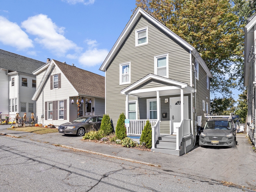 85 B Street Lowell, MA 01851 - Photo 29 of 42 a view of a white house with large windows next to a road