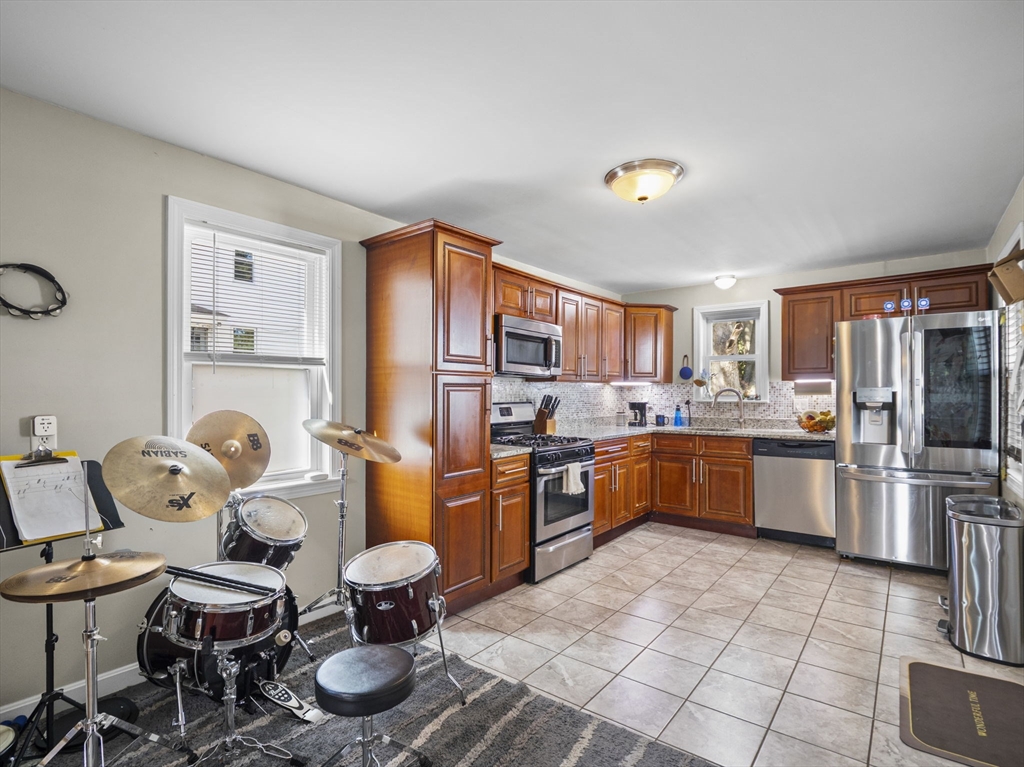85 B Street Lowell, MA 01851 - Photo 7 of 42 a kitchen with stainless steel appliances granite countertop a refrigerator and a stove top oven