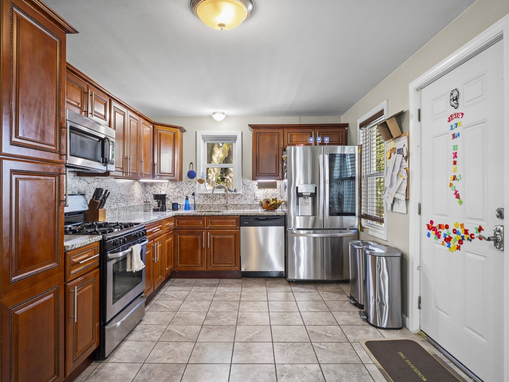 85 B Street Lowell, MA 01851 - Photo 8 of 42 a kitchen with a sink stainless steel appliances and cabinets