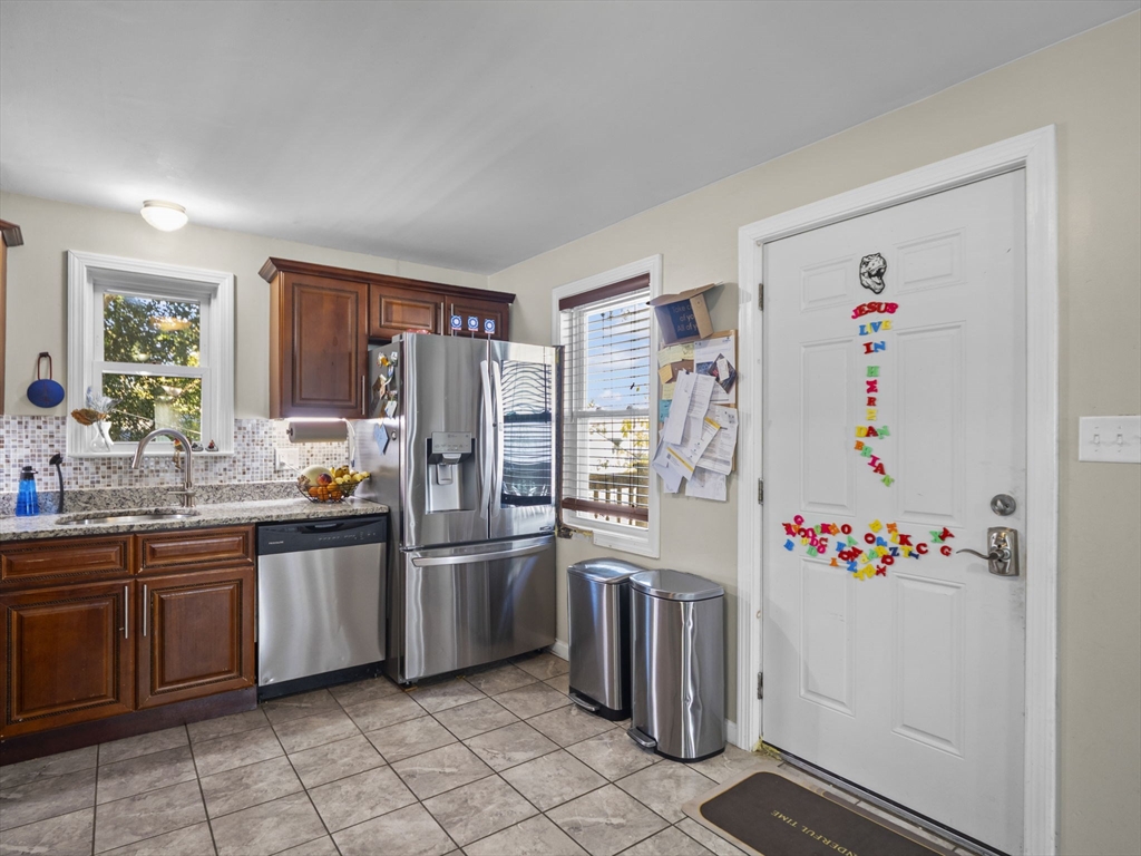 85 B Street Lowell, MA 01851 - Photo 9 of 42 a kitchen with stainless steel appliances a refrigerator and a sink