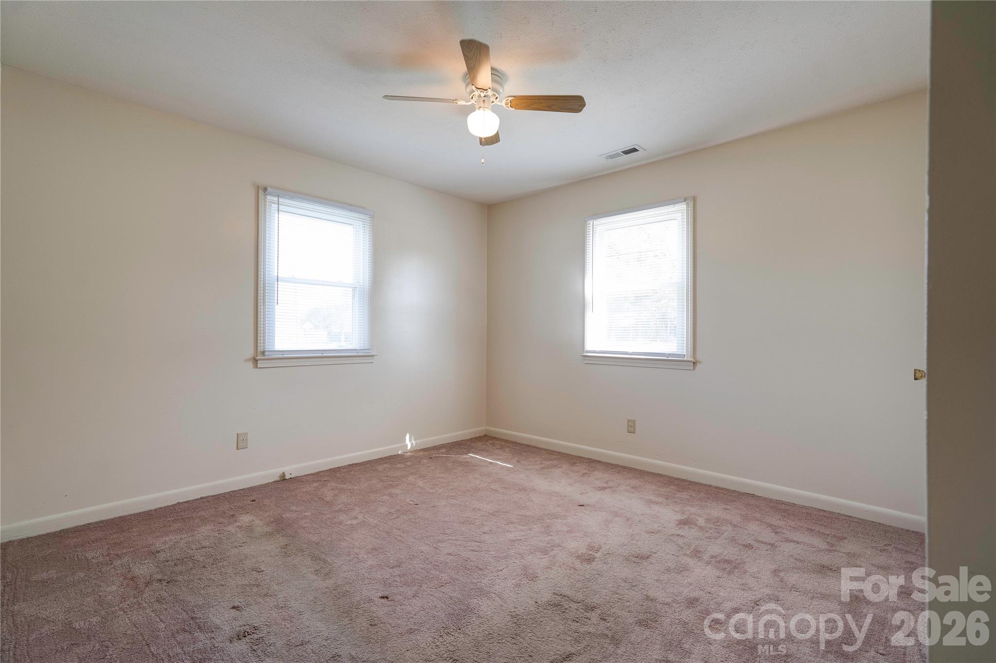 1904 Sulphur Springs Road Shelby, NC 28152 - Photo 13 of 27 an empty room with windows and a ceiling fan