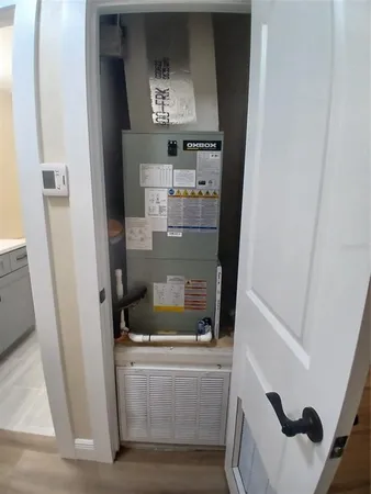 a room with water heater and white cabinets
