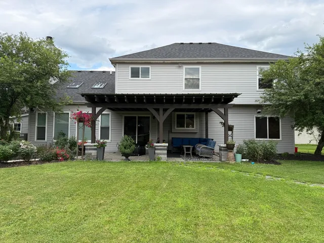 a front view of a house with a yard and trees