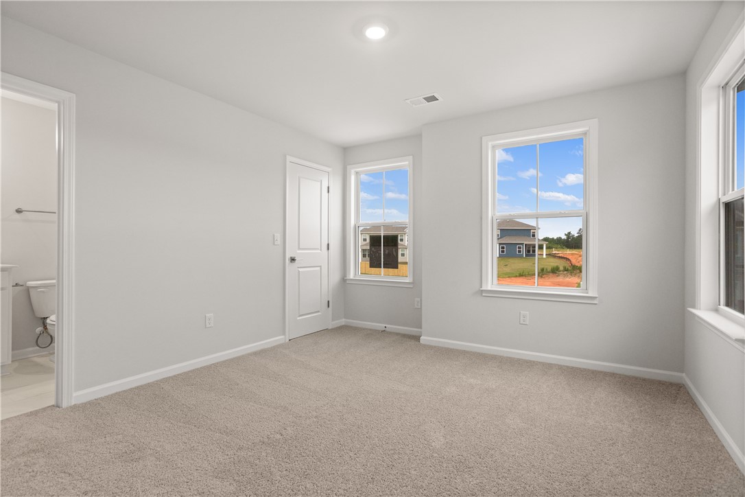 631 Sweetspire Trail, Unit 148 Seneca, SC 29678 - Photo 17 of 36 A well-lit bedroom with soft carpeting and multiple windows.