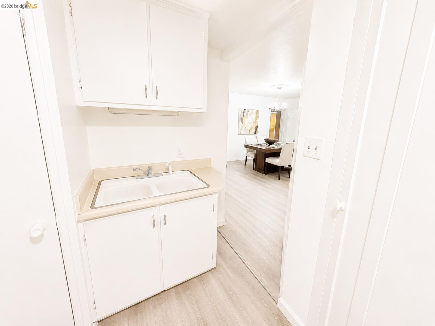 810 Pierce Street Albany, CA 94706 - Photo 20 of 25 Utility area featuring white cabinetry, a double basin sink, and a light-toned countertop
