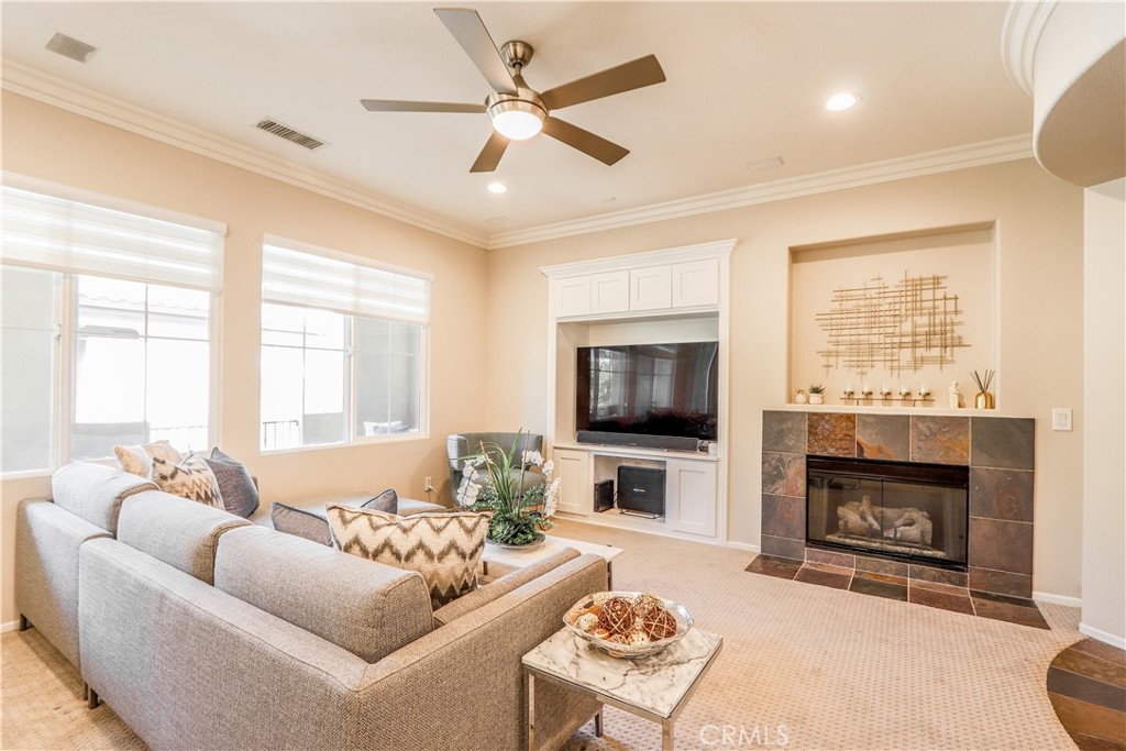 a living room with furniture a fireplace and a flat screen tv