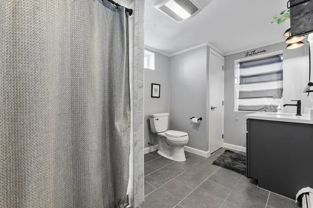 a bathroom with a toilet a sink and a window