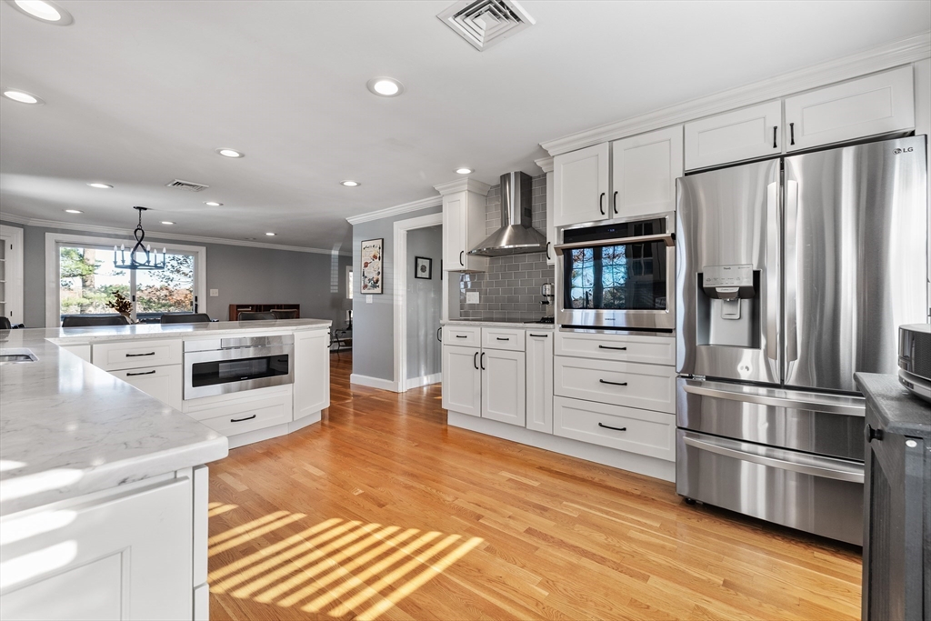 3 Suntaug Street Lynnfield, MA 01940 - Photo 21 of 42 a kitchen with stainless steel appliances kitchen island granite countertop a refrigerator and a stove top oven