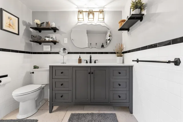 a bathroom with a sink a toilet and a mirror