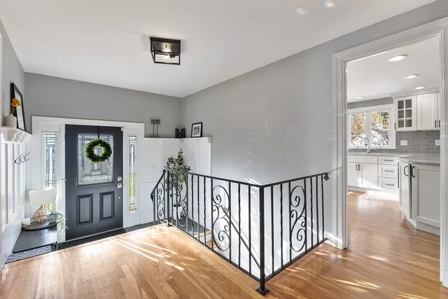 a view of a hallway with a dining table chairs