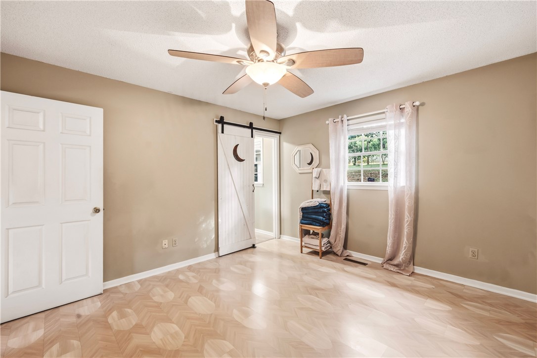 2001 Ridgeview Lane Seneca, SC 29678 - Photo 17 of 27 A quiet bedroom features a statement barn door and patterned flooring.