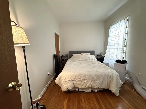 a bed sitting in a bedroom next to a window