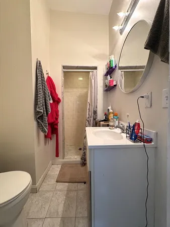 a bathroom with a sink vanity mirror and toilet