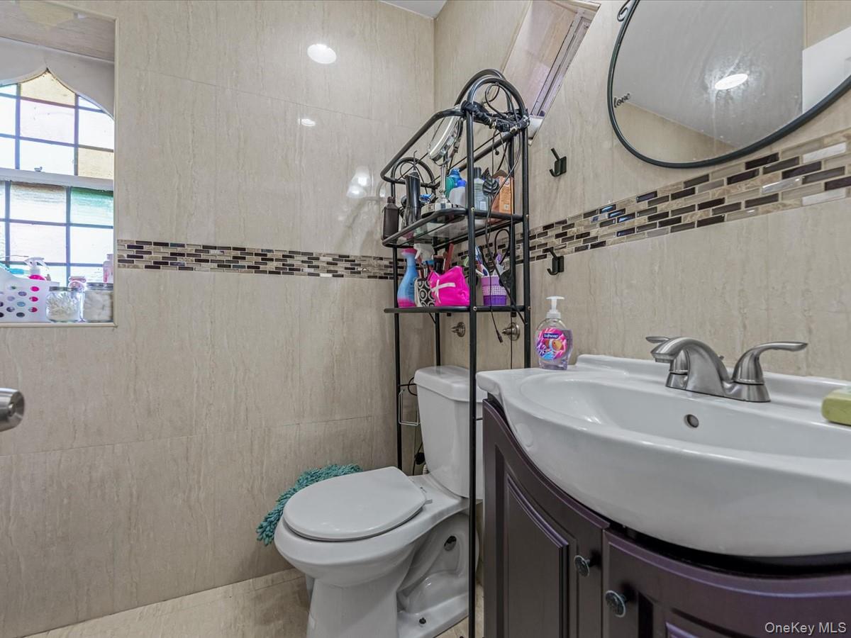 172-09 Sayres Avenue Queens, NY 11433 - Photo 17 of 23 a bathroom with a sink a toilet and a mirror